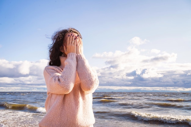 Die Brünette bedeckt ihr Gesicht mit ihren Händen ein Mädchen in einer tiefen Depression die Frau hat eine Tragödie die ...