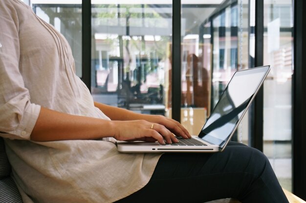 Die Casual Business-Frau arbeitet online auf Laptop, die Hand auf Tastatur in ihrem Haus Isolierte Bildschirm im Laptop.