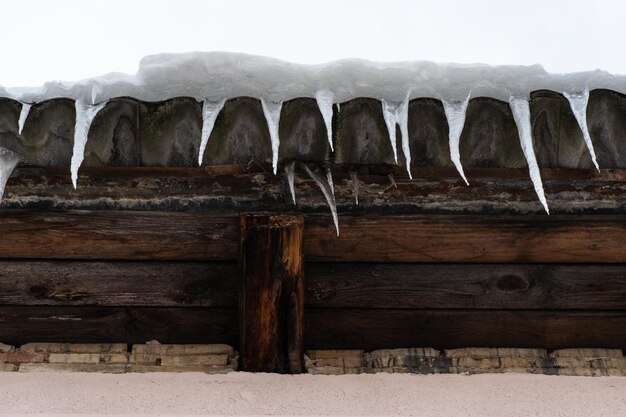 Die Dächer der Gebäude sind nach einem großen Schneefall mit Schnee und Eis bedeckt. Riesige Eiszapfen hängen von den Fassaden der Gebäude. Der Fall von Eiszapfen birgt Lebensgefahr für Menschen