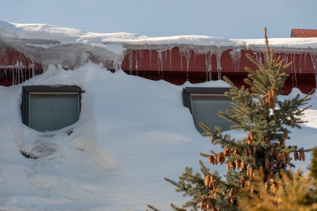 Die Dächer der Gebäude sind nach einem großen Schneefall mit Schnee und Eis bedeckt. Riesige Eiszapfen hängen von den Fassaden der Gebäude. Der Fall von Eiszapfen birgt Lebensgefahr für Menschen