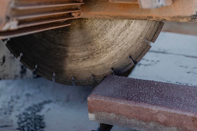 Die Diamantkreissäge schneidet Betonplatten. Betonschneidemaschine Nahaufnahme.