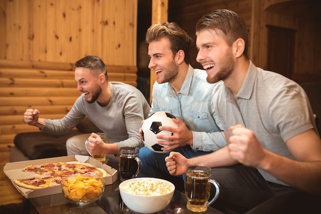 Die drei Emotionsmänner schauen sich Fußball an und gestikulieren