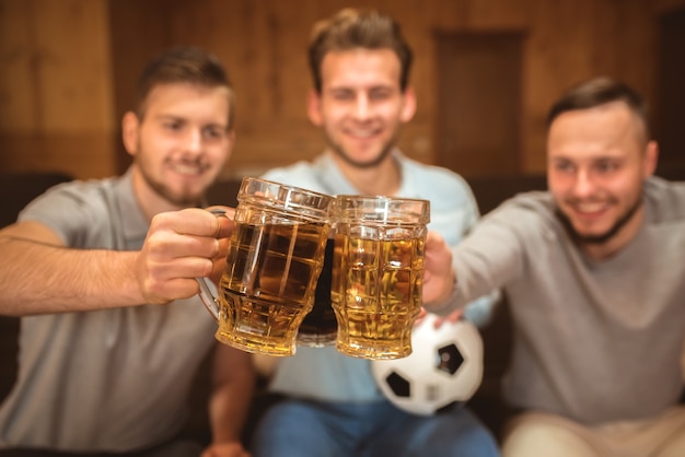 Die drei Freunde stoßen mit einem Bier an