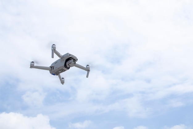 Die Drohne fliegt am blauen Wolkenhimmel Neue Technologien für Foto- und Videoaufnahmen