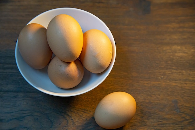 Die Eier in der Schüssel auf hölzerner Tabelle für Lebensmittelinhalt.