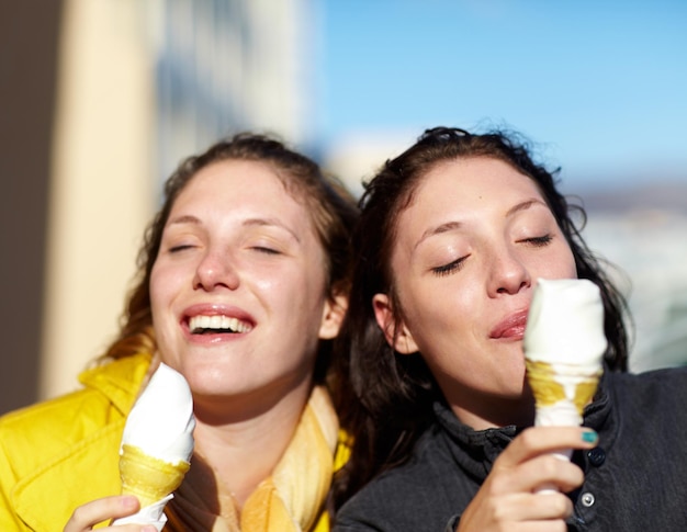 Die einfachen Freuden des Lebens Aufnahme von zwei Schwestern im Teenageralter, die draußen Eis essen