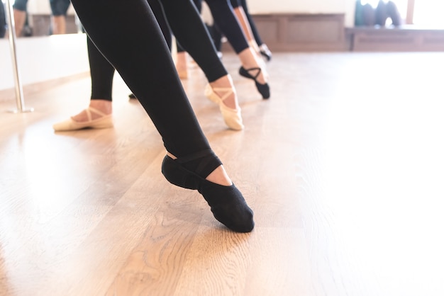 Die eleganten Beine von Balletttänzern stehen in einer Reihe auf den Zehen