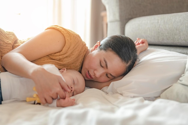 Die Eltern liegen gemächlich und wiegen ihre Kinder zum Mittagessen im Wohnzimmer des Hauses ein. Familie, Elternteil, Sohn, Baby, glücklich, Lifestyle-Konzept.