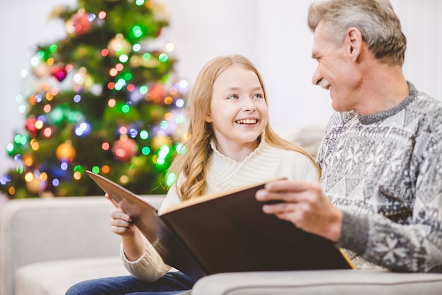 Die Enkelin und ein Großvater haben das Buch neben dem Weihnachtsbaum gelesen