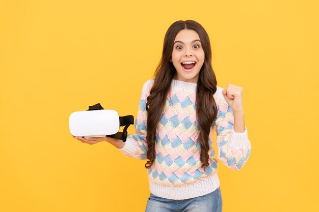 Die Entwicklung der Kindheit erstaunte ein Teenager-Mädchen, das eine drahtlose VR-Brille mit einem VR-Headset hält. Das Kind spielt ein Videospiel. Digitale Zukunft und Innovation