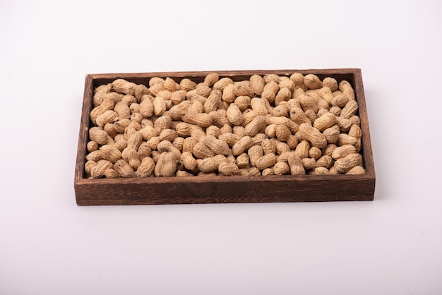 Die Erdnüsse in der quadratischen Platte sind auf einem weißen Hintergrund