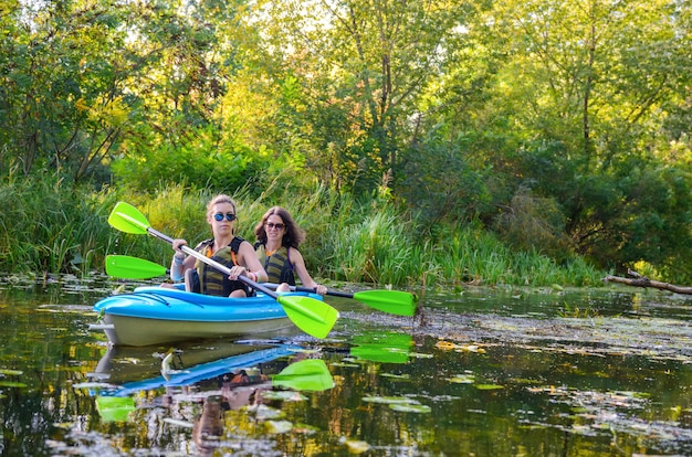 Die Familie, die im Kajak auf Flusskanu Kayak fährt, Mutter und Tochter, die Spaß haben, aktives Herbstwochenende und Ferien mit Kindern, Eignungskonzept