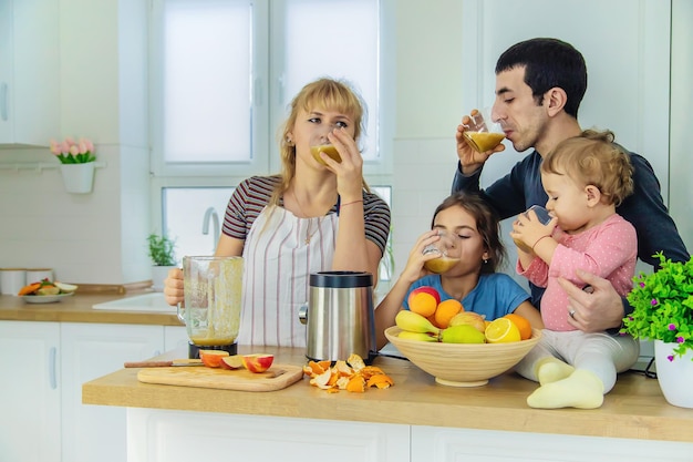 Die Familie macht Smoothies in der Küche. Selektiver Fokus.