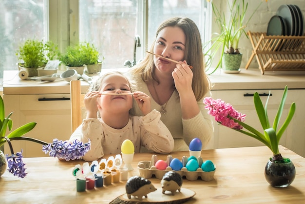 Die Familie malt bunte Ostereier Mutter und Tochter feiern gemeinsam Frühlingsferien