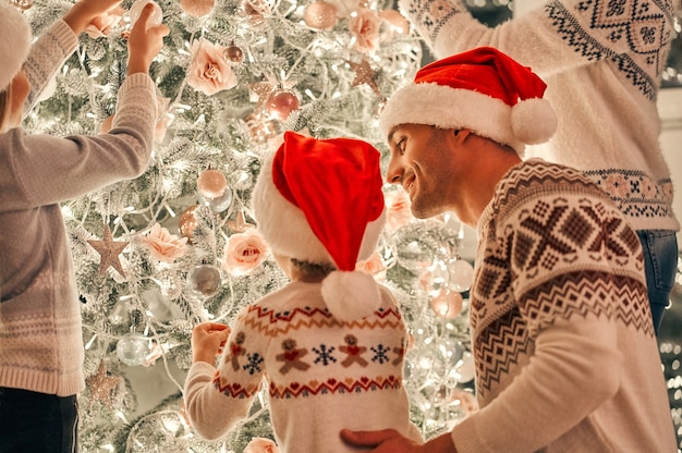 Die Familie schmückt den Weihnachtsbaum