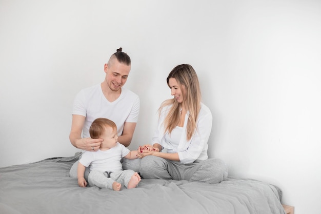 Die Familie sitzt auf dem Bett. Mama Papa und Sohn