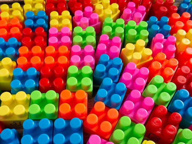 Die Farbspielzeugziegel auf Holztisch für Hintergrund- oder Bildungskonzept