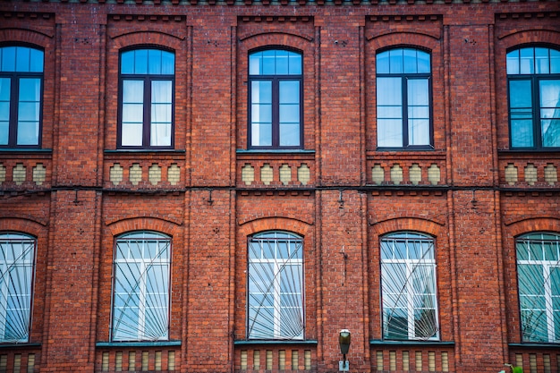 Die Fassade des Gebäudes aus roten Backsteinen mit Fenstern