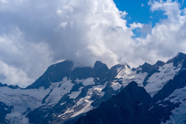 Die felsigen Berge waren an einem sonnigen Tag in Wolken gehüllt Atemberaubende Aussicht auf die Berge