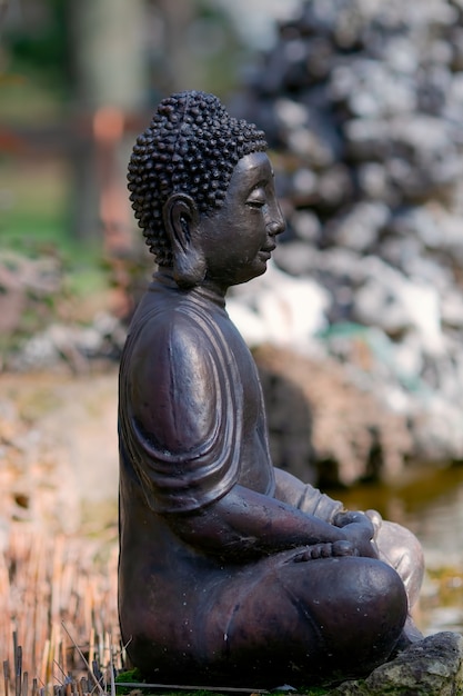 Die Figur eines Buddha, der in einer Lotus-Pose sitzt, besteht aus Metall