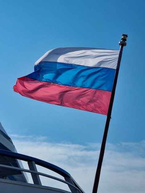 Die Flagge der Russischen Föderation vor dem Hintergrund eines blauen Himmels