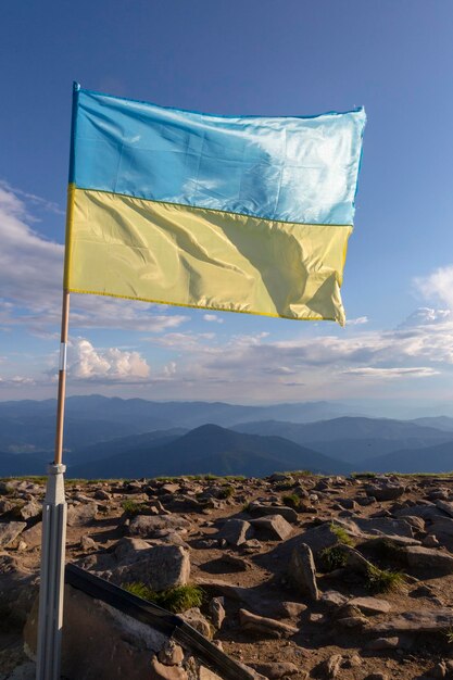 Die Flagge der Ukraine flattert im Wind auf einem Berg in den Karpaten