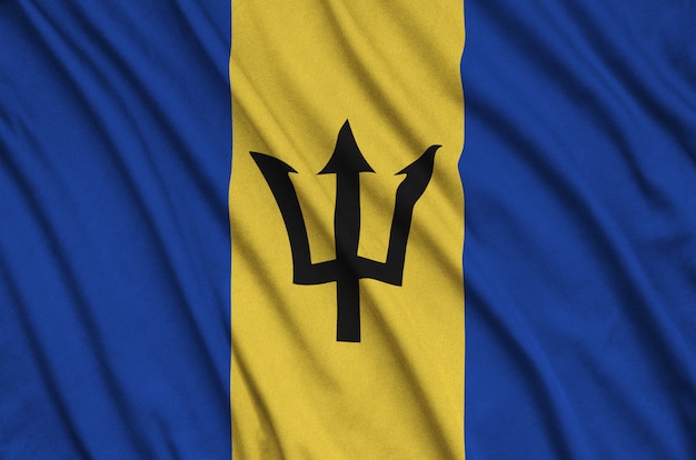 Die Flagge von Barbados ist auf einem Sportstoff mit vielen Falten abgebildet.