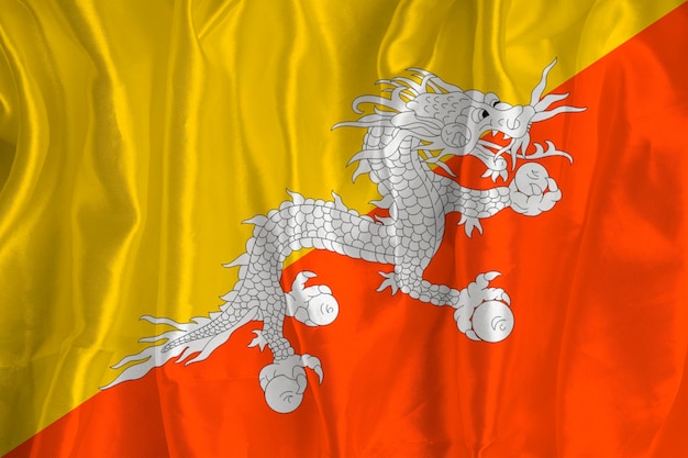 Die Flagge von Bhutan auf Seidenhintergrund ist ein großes nationales Symbol Stoffstruktur Das offizielle Staatssymbol des Landes