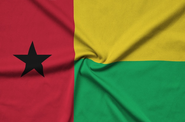 Die Flagge von Guinea-Bissau ist auf einem Sportstoff mit vielen Falten abgebildet.