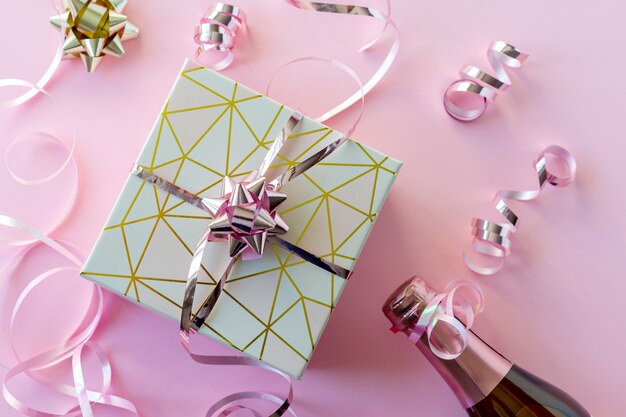 Foto die flasche champagner mit rosa glänzendem band und rosa geschenkbox. 2021 frohes neues jahr konzept.