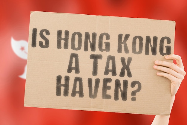 Die Frage ist Hongkong ein Steuerparadies auf einem Banner in Männerhänden mit einer verschwommenen Hongkong-Flagge im Hintergrund