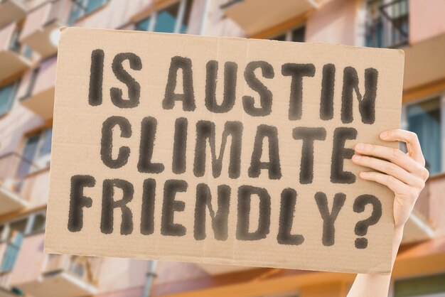 Die Frage, ob Austin klimafreundlich ist, steht auf einem Banner in Männerhänden mit verschwommenem Hintergrund Support Team Aktivist Städtischer Sonnenuntergang Kohlenstoff Ökologie Energie Neu Sauber Erwärmung Abfall