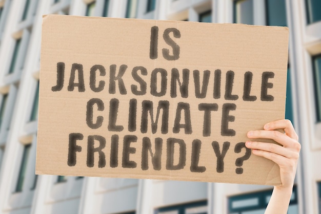 Die Frage, ob Jacksonville klimafreundlich ist, steht auf einem Banner in den Händen von Männern mit verschwommenem Hintergrund. Support Team Aktivist Städtischer Sonnenuntergang Kohlenstoffökologie Energie Neu Sauber Erwärmung Abfall