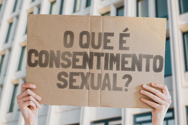 Die Frage Was ist sexuelle Zustimmung auf einem Banner in den Händen von Männern mit verschwommenem Hintergrund Intimität Intim Sex Erwachsenenrecht Beziehung Liebe Legalität