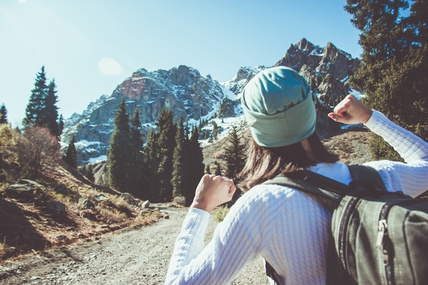 Die Frau ballt die Fäuste. Reise zum Berggipfel.