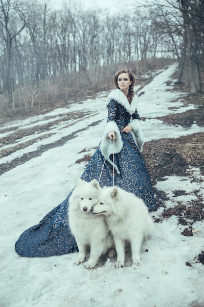 Die Frau beim Winterspaziergang mit einem Hund