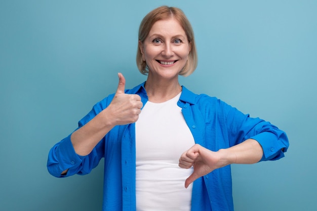 Die Frau der Blondine zeigt Vorliebe und Abneigung auf blauem Hintergrund mit Copyspace