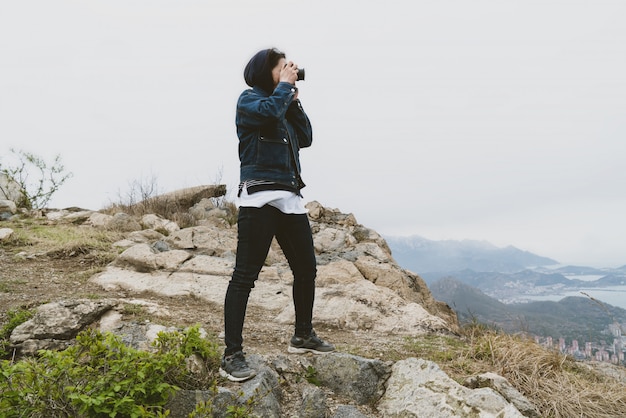 Die Frau, die oben auf dem Berg fotografiert