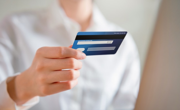 Die Frau, die online kauft und Ansicht der Kreditkarte zurückhält, geben den Zahlungscode für das Produkt ein.