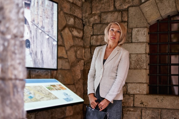 Die Frau im Museum verwendet den elektronischen Führer des Touchscreen-Monitors, das Konzept des modernen Lebens