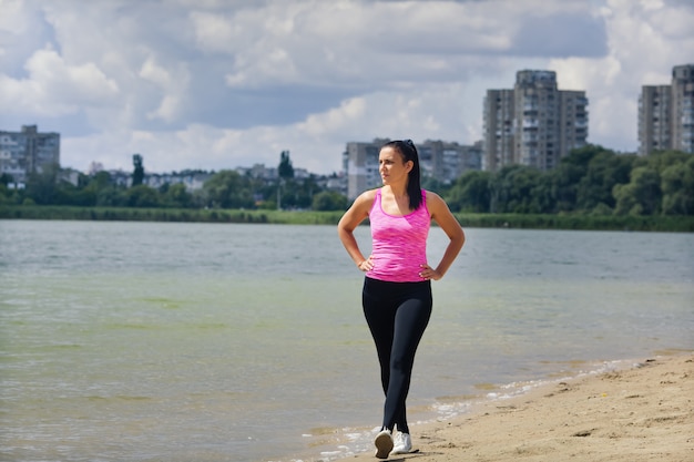 Foto die frau in einer sportuniform geht in der nähe des sees