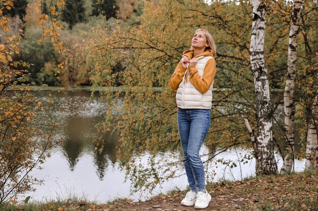 Die Frau ist im Herbstpark Herbstatmosphäre malerische Aussicht auf den Fluss