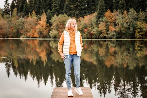 Die Frau ist im Herbstpark Herbstatmosphäre malerische Aussicht auf den Fluss