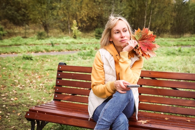 Die Frau ist im Herbstpark Herbststimmung