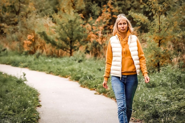 Die Frau ist im Herbstpark Spaziergang durch den Wald Herbststimmung