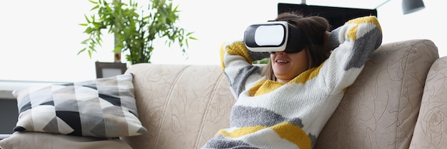 Die Frau lag lässig auf der Couch in einer VR-Brille und benutzte ein modernes Gerät zu Hause, um die Neuentwicklung zu testen