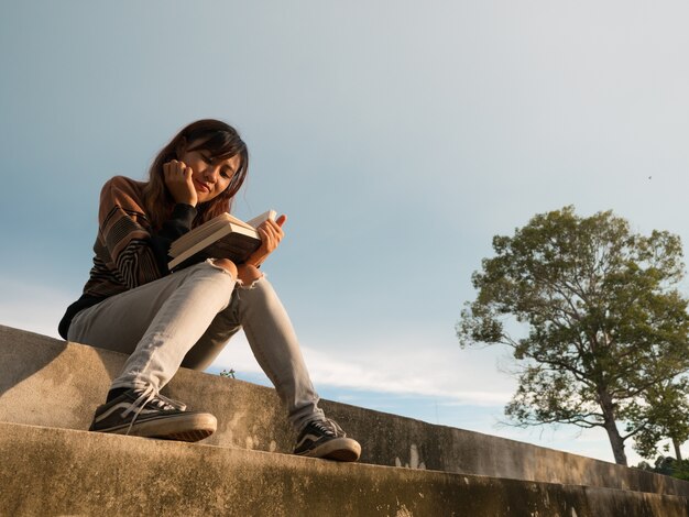 Foto die frau liest das buch in der natur.