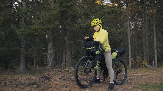 Die Frau reist auf Fahrradtouren mit Bikepacking in gemischtem Gelände