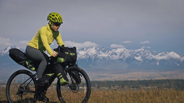 Die Frau reist auf Fahrradtouren mit Bikepacking in gemischtem Gelände