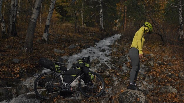 Die Frau reist auf Fahrradtouren mit Bikepacking in gemischtem Gelände